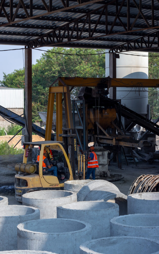 Operários fazendo tubos de concreto